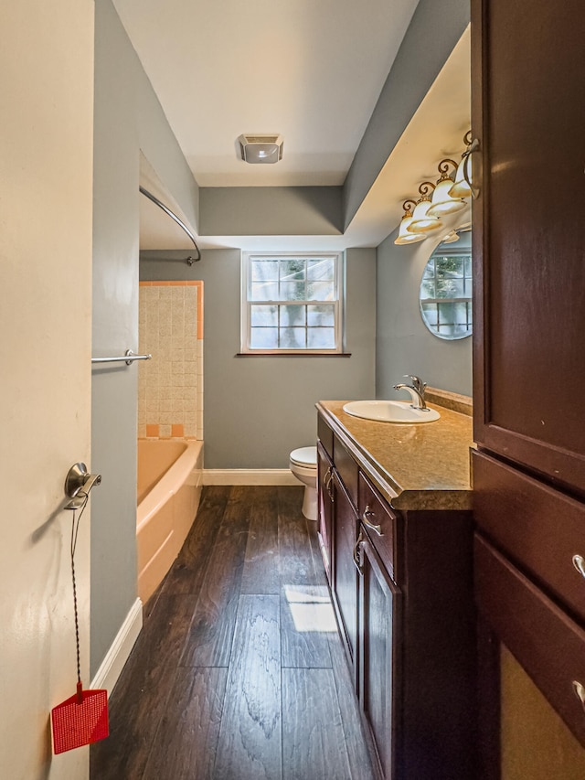 full bathroom featuring hardwood / wood-style floors, toilet, plenty of natural light, and vanity