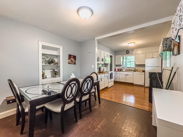 dining area with dark hardwood / wood-style flooring and sink