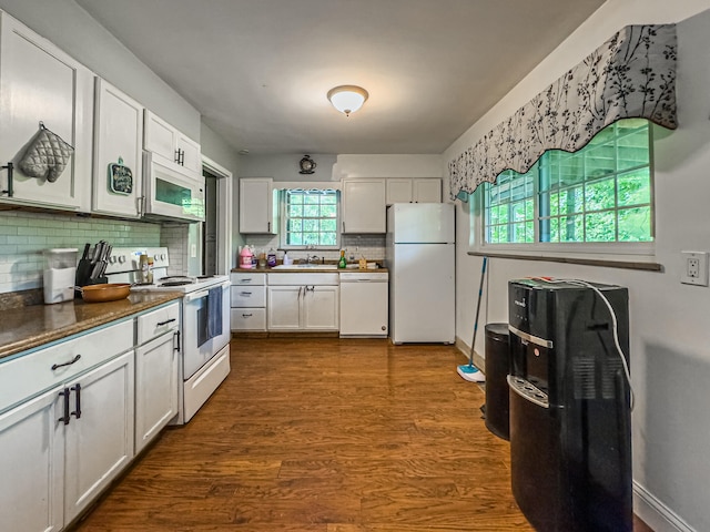 kitchen with white cabinetry, white appliances, backsplash, sink, and dark wood-type flooring