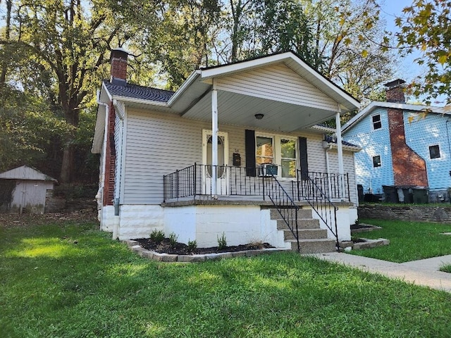 bungalow-style home featuring covered porch and a front lawn