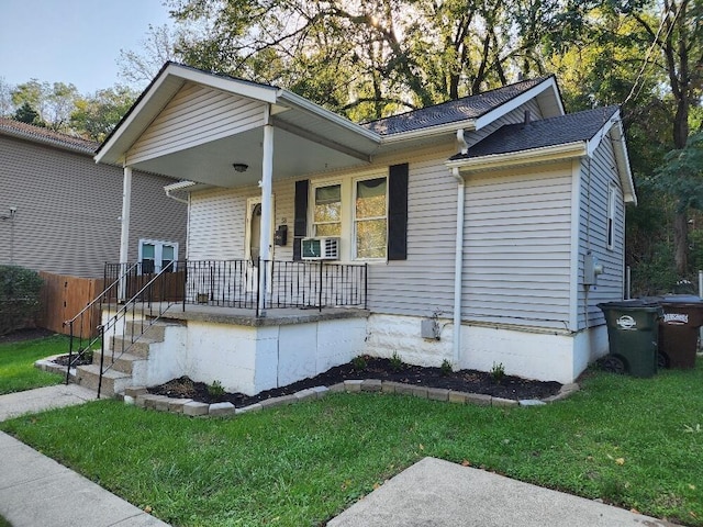 view of front of property featuring cooling unit, a front lawn, and a porch