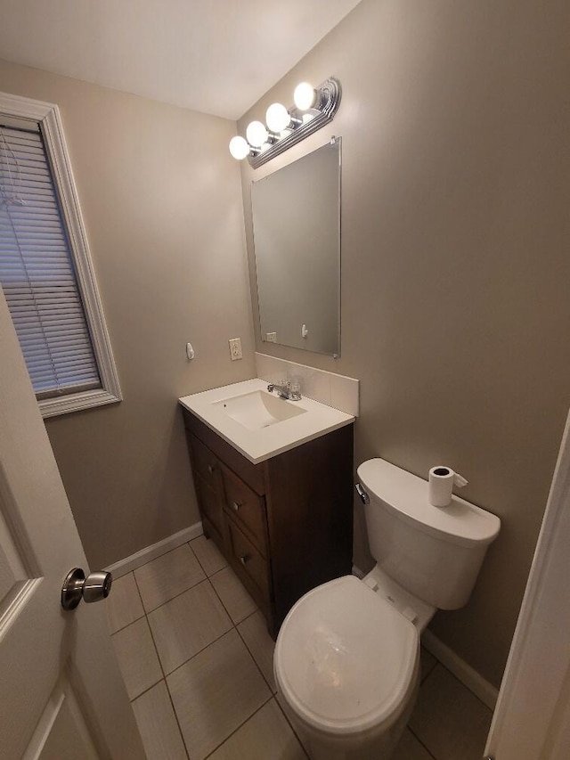 bathroom with tile patterned flooring, vanity, and toilet