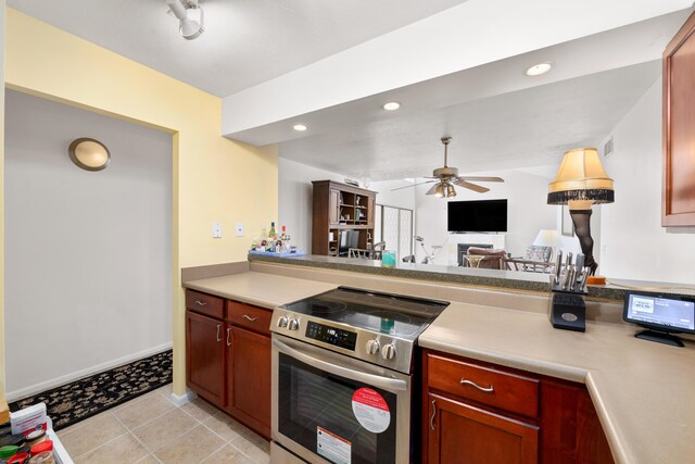 kitchen featuring stainless steel electric stove, ceiling fan, light tile patterned flooring, and kitchen peninsula