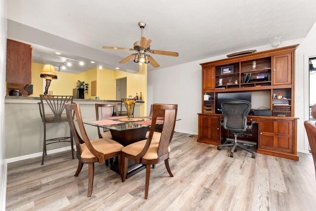 dining space with light hardwood / wood-style flooring and ceiling fan