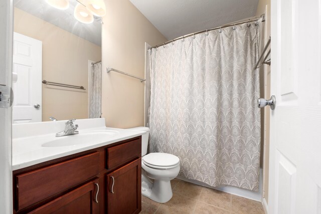 bathroom with tile patterned flooring, vanity, and toilet