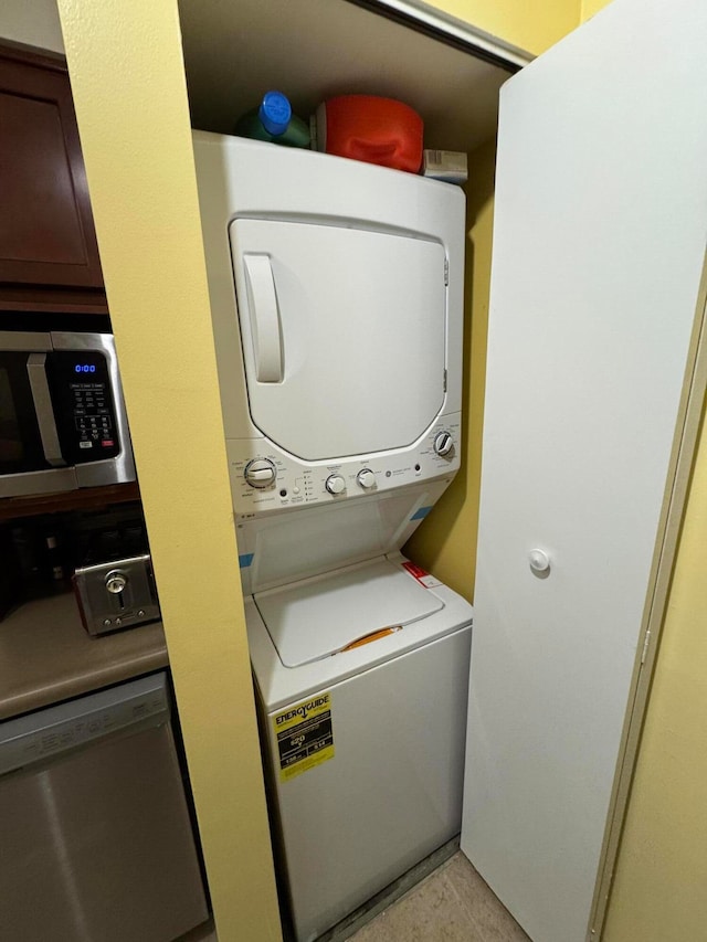 laundry room featuring light tile patterned floors and stacked washer and clothes dryer