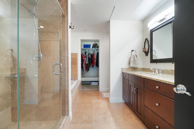 bathroom featuring a shower with shower door and vanity