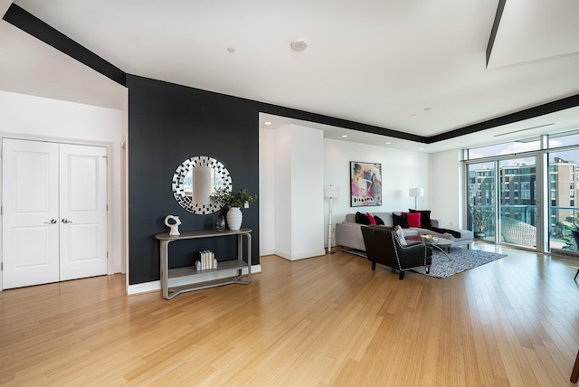 living room with light hardwood / wood-style floors and a wall of windows