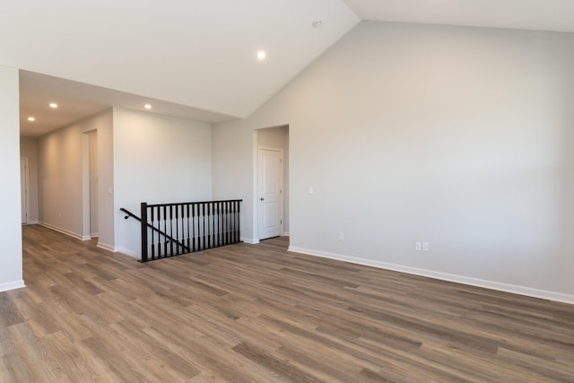 unfurnished room with dark wood-type flooring and high vaulted ceiling