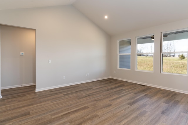 empty room featuring vaulted ceiling and dark hardwood / wood-style floors