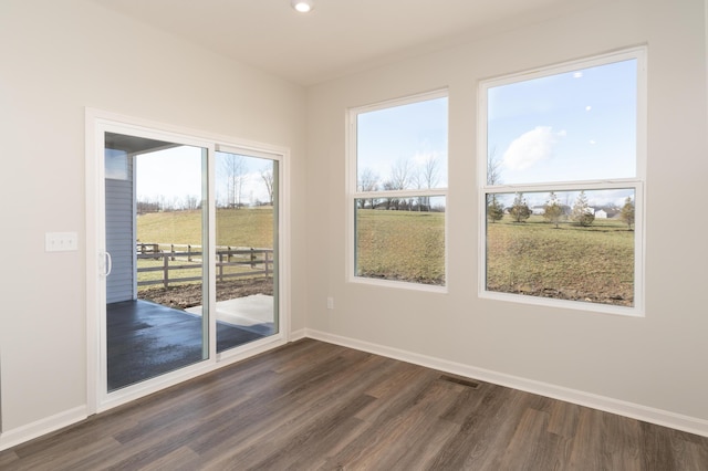 unfurnished room with dark hardwood / wood-style floors and a rural view