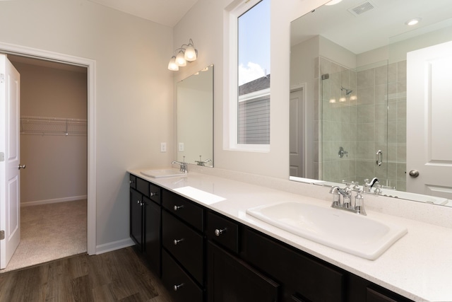 bathroom featuring vanity, an enclosed shower, and wood-type flooring