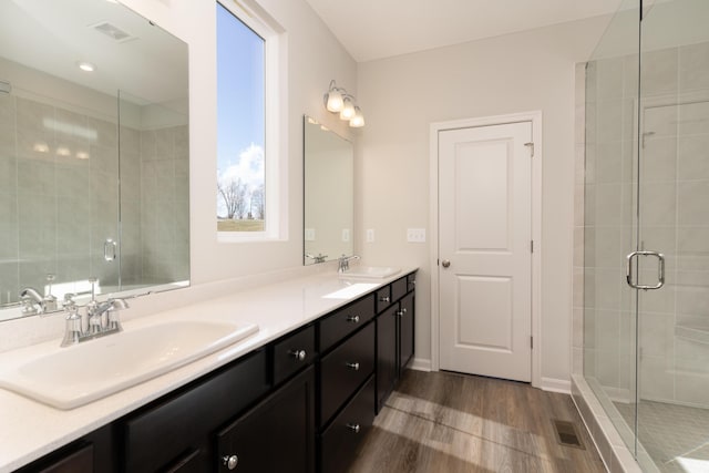 bathroom featuring wood-type flooring, vanity, and walk in shower