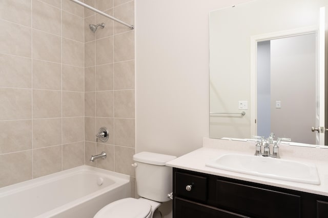 full bathroom with tiled shower / bath, vanity, and toilet