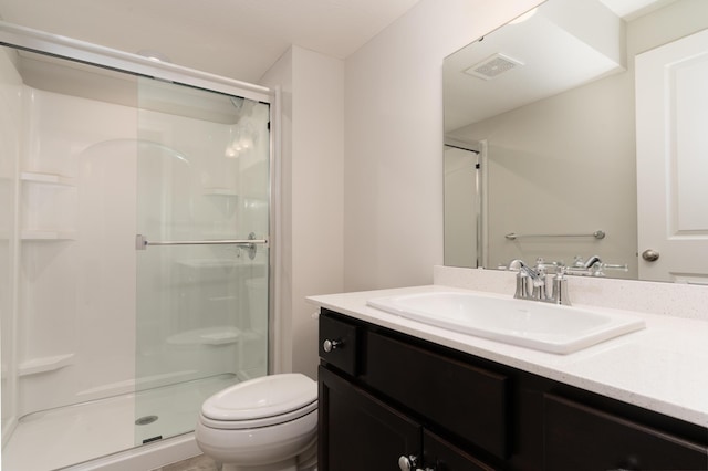 bathroom featuring vanity, toilet, and a shower with shower door