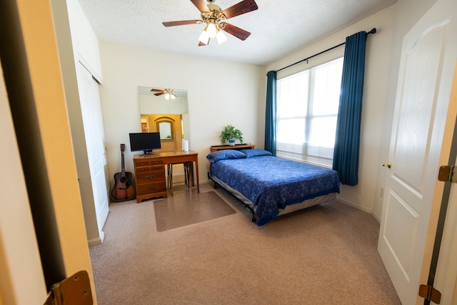 bedroom featuring carpet, a textured ceiling, and ceiling fan