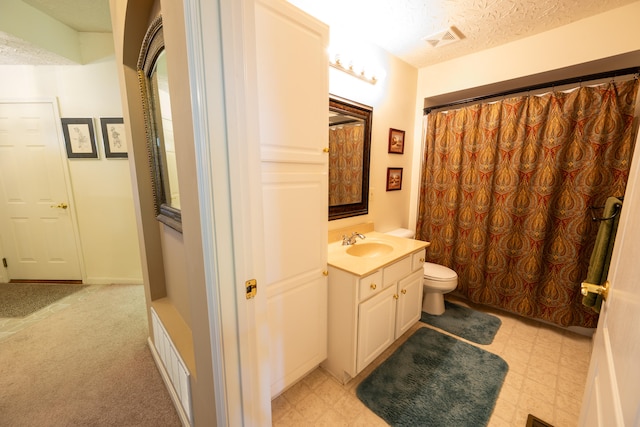 bathroom featuring vanity, a textured ceiling, and toilet