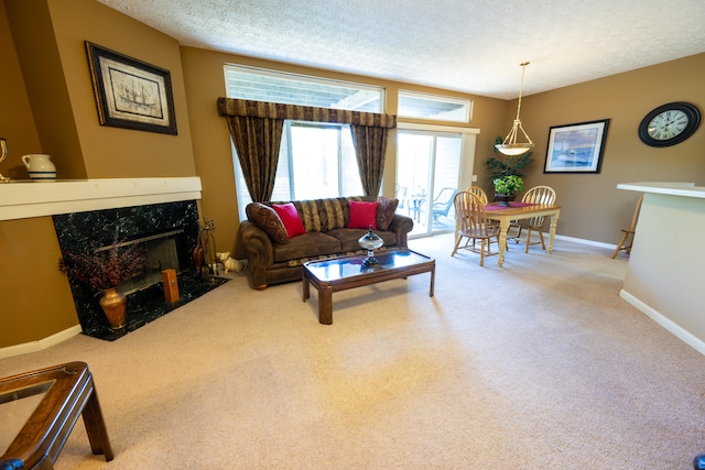 living room with a high end fireplace, carpet flooring, and a textured ceiling