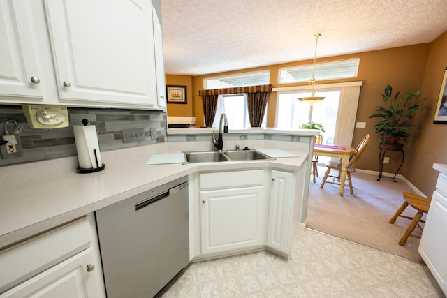 kitchen featuring sink, white cabinetry, hanging light fixtures, stainless steel dishwasher, and kitchen peninsula