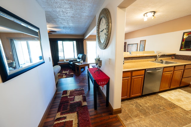 kitchen with dishwasher, sink, and a textured ceiling