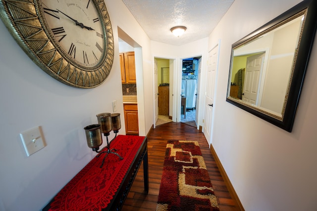 hallway featuring dark hardwood / wood-style flooring and a textured ceiling