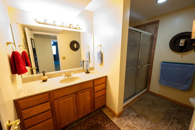 bathroom with vanity, toilet, and a shower with shower door