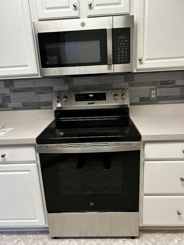 kitchen featuring backsplash, white cabinets, and appliances with stainless steel finishes