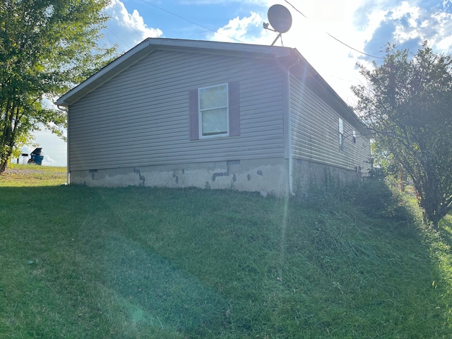 view of side of home with a yard