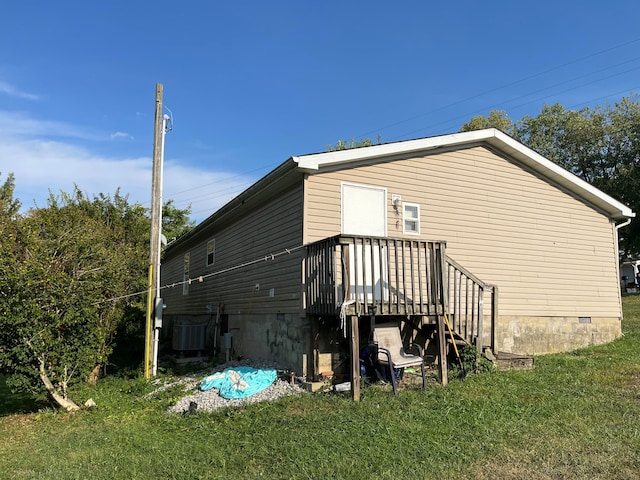 rear view of house featuring a lawn, cooling unit, and a deck