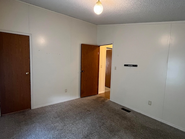 carpeted empty room with a textured ceiling and vaulted ceiling