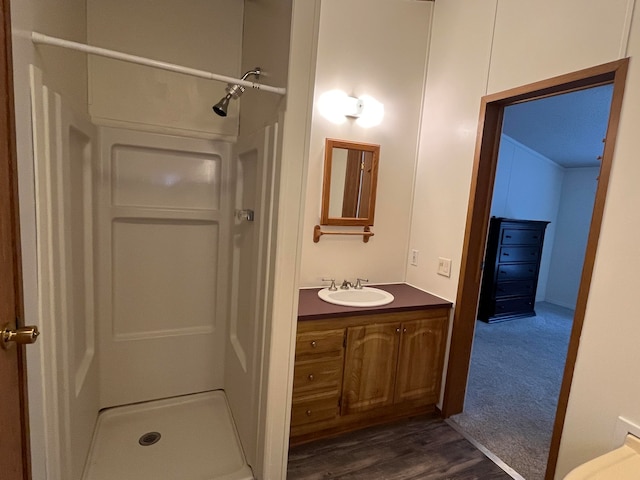 bathroom featuring walk in shower, wood-type flooring, and vanity