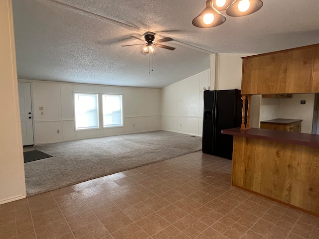 kitchen featuring black fridge with ice dispenser, a textured ceiling, lofted ceiling, ceiling fan, and carpet