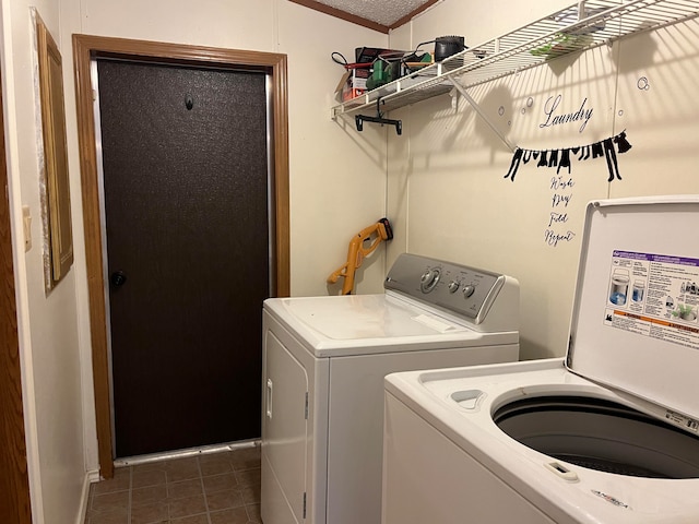 laundry room with dark tile patterned floors and washing machine and dryer