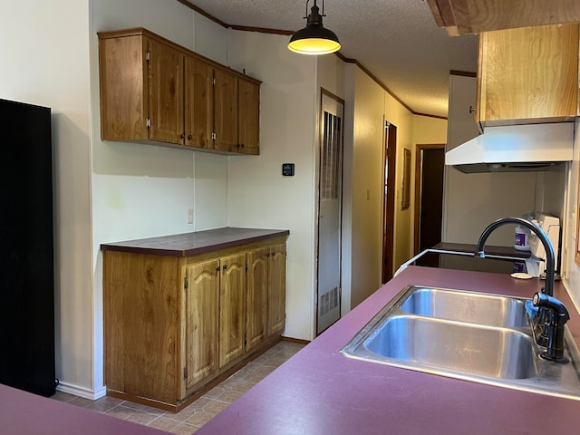 kitchen featuring a textured ceiling, crown molding, hanging light fixtures, and sink