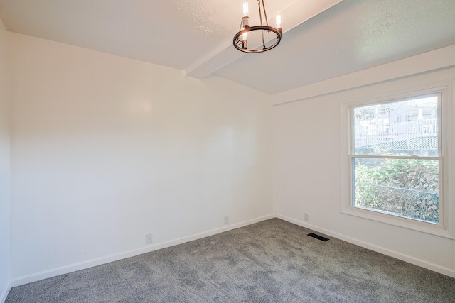 empty room featuring carpet, beam ceiling, a chandelier, and a wealth of natural light