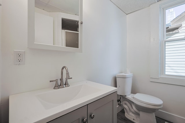 bathroom with a textured ceiling, vanity, and toilet