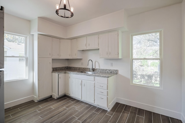 kitchen with white cabinets, an inviting chandelier, dark hardwood / wood-style floors, and sink