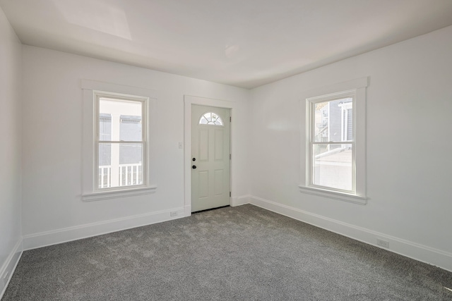 foyer with dark carpet and plenty of natural light