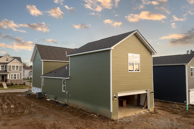 view of side of home with cooling unit and a garage