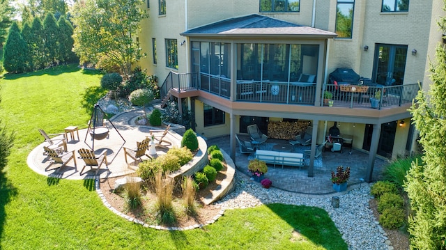 back of house with a lawn, an outdoor hangout area, a patio, and a sunroom