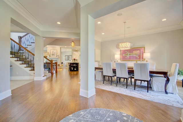 dining space with crown molding and light hardwood / wood-style flooring