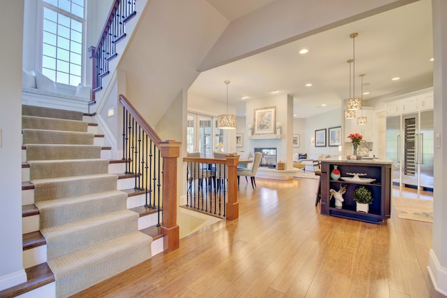 staircase featuring a multi sided fireplace and wood-type flooring