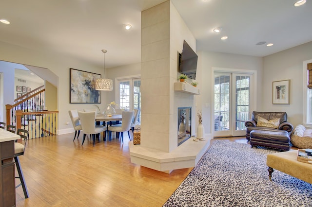 living room featuring light hardwood / wood-style floors, a wealth of natural light, and a tile fireplace