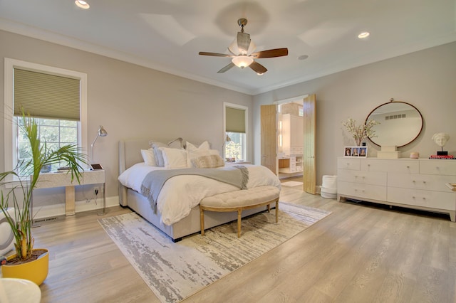 bedroom with ceiling fan, ornamental molding, connected bathroom, and multiple windows