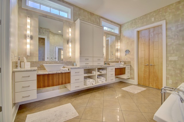 bathroom with decorative backsplash, a high ceiling, tile patterned floors, a washtub, and vanity