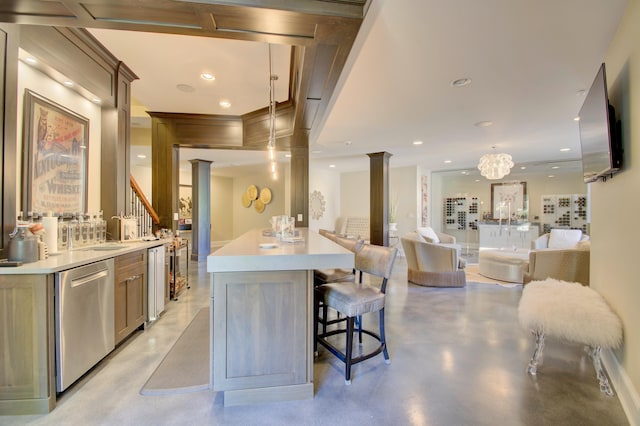 kitchen with decorative columns, a kitchen breakfast bar, pendant lighting, and stainless steel dishwasher