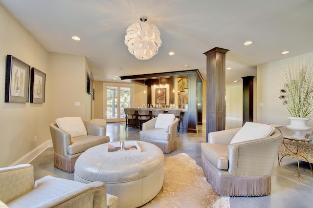 living room featuring decorative columns and a notable chandelier