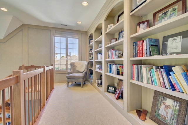 living area featuring light colored carpet and built in features