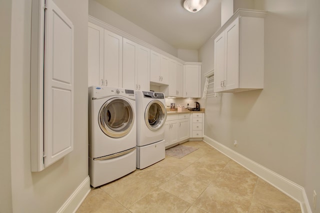 clothes washing area with washing machine and dryer, cabinets, and light tile patterned flooring