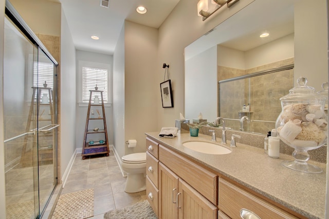 bathroom with tile patterned floors, toilet, a shower with door, and vanity